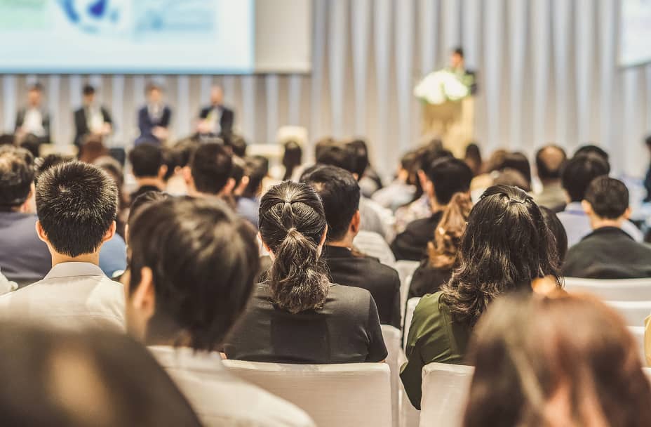 多くの人が座って登壇者の話を聞いている講演会の様子